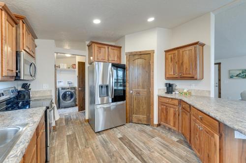 a kitchen with wooden cabinets and a stainless steel refrigerator at Beautiful Tetonia Escape with Porch and Teton Views in Tetonia