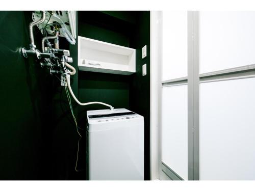 a washing machine in a bathroom next to a window at VILLA KOSHIDO ODORI - Vacation STAY 04745v in Sapporo