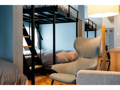 ein Wohnzimmer mit einem Stuhl und einem Etagenbett in der Unterkunft VILLA KOSHIDO ODORI - Vacation STAY 04767v in Sapporo