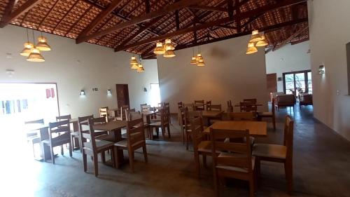 uma sala de jantar com mesas e cadeiras de madeira em Pousada Lençóis Eco Villa em Santo Amaro