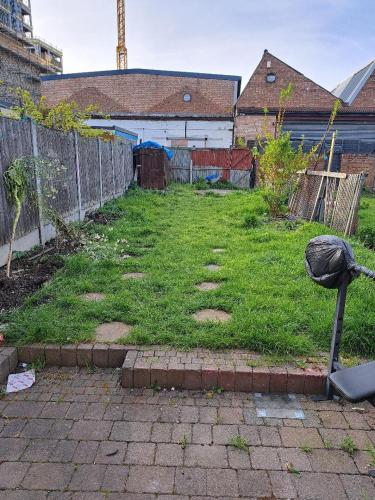 a yard with a fence and a field of grass at Single Bedroom near London Seven Kings Train Station in Seven Kings