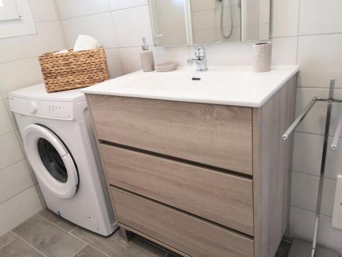 Un baño con lavabo y lavadora. en Marina Smeraldo, en Castelsardo