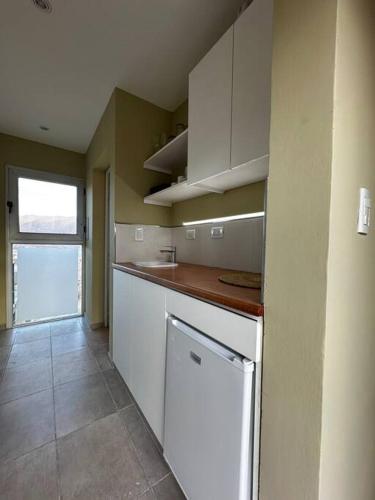 a kitchen with white cabinets and a dishwasher at Villamagna, casa en Potrerillos in Potrerillos
