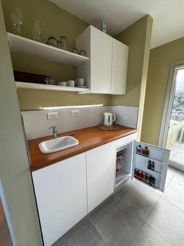 a small kitchen with white cabinets and a sink at Villamagna, casa en Potrerillos in Potrerillos
