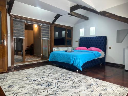 a bedroom with a blue bed with pink pillows at Konak Kardelen in Yıldırım