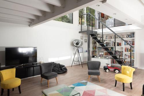 a living room with yellow chairs and a staircase at Spacious and quiet apartment with shared garden in Issy-les-Moulineaux