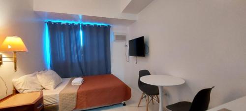 a room with a bed and a desk and a table at Roxas Blvd Stunning Studio Condo Near US Embassy in Manila