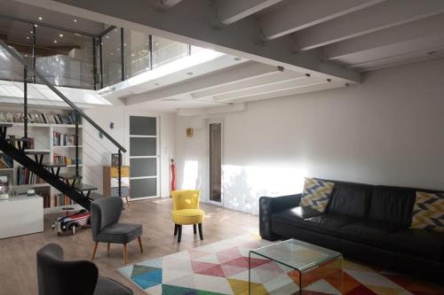 - un salon avec un canapé noir et un fauteuil jaune dans l'établissement Spacious and quiet apartment with shared garden, à Issy-les-Moulineaux