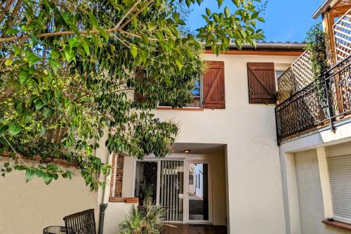 ein weißes Haus mit einer Tür und einem Baum in der Unterkunft Grand duplex - Parking privé - Centre - Calme in Toulouse