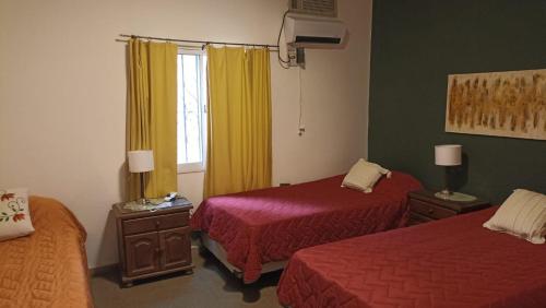 Habitación de hotel con 2 camas y ventana en La Pirca Rosada en San Fernando del Valle de Catamarca