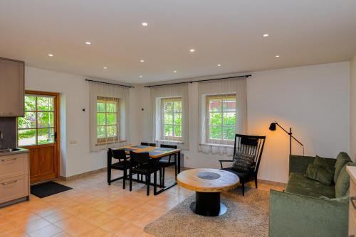a living room with a table and a couch at Apartamentai Gėlių Vila in Nida