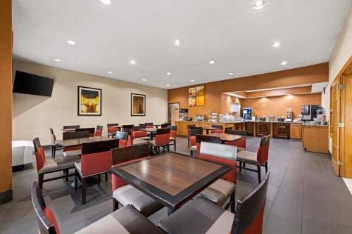 een eetkamer met tafels en stoelen en een keuken bij Comfort Suites Kansas City-Liberty in Liberty