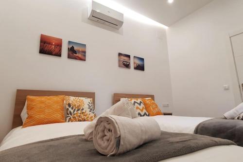 2 camas en una habitación con paredes blancas en Preciosa casa reformada a 20 min de Barcelona, en Cabrils