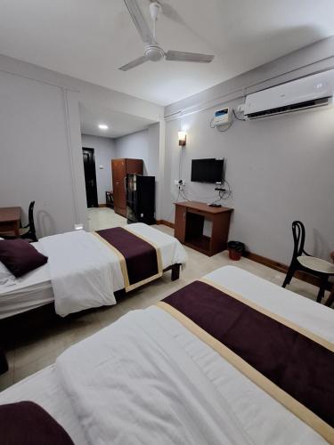 a hotel room with two beds and a television at Hotel Chhungte International in Āīzawl