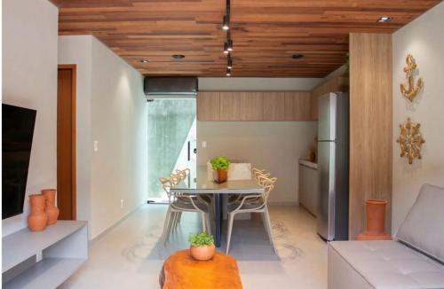 a kitchen and living room with a table and a refrigerator at Vila Piá in Piaçabuçu