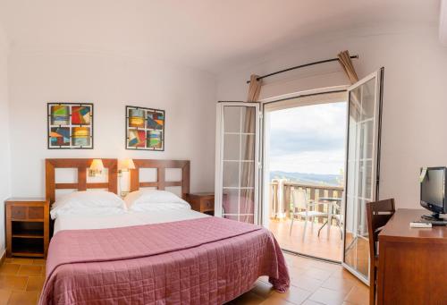 1 dormitorio con 1 cama y balcón en Complejo Los Veneros, en Santa Ana la Real
