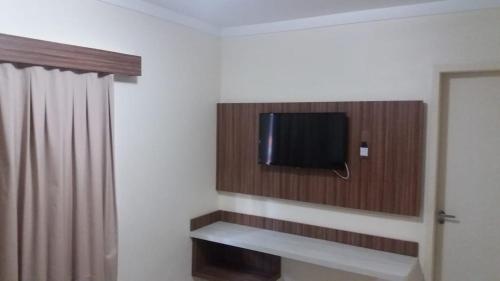 Habitación con TV de pantalla plana en la pared en Reserve Caldas Lacqua I, en Caldas Novas