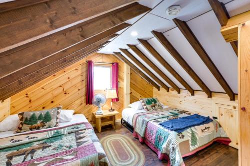 2 camas en una habitación con paredes de madera en Cozy Chemo Pond Cabin with Dock and Waterfront Views, 