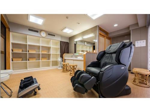 ein Zimmer mit einem Salon mit einem Stuhl und einem Tisch in der Unterkunft Green Hotel Kitakami - Vacation STAY 09848v in Kitakami