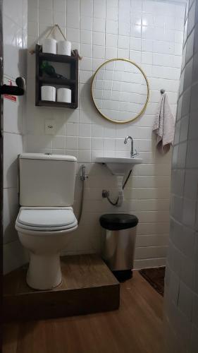 een badkamer met een toilet, een wastafel en een spiegel bij Paz e Amor Suite in Abraão