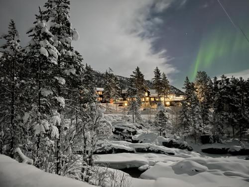 Una casa nella neve con un arcobaleno nel cielo di Pollfoss Hotell a Skjåk