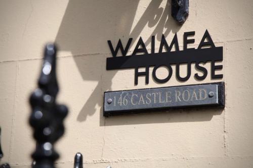 a sign for a walinga house on a building at Waimea House Beach Front The best sea views in Scarborough