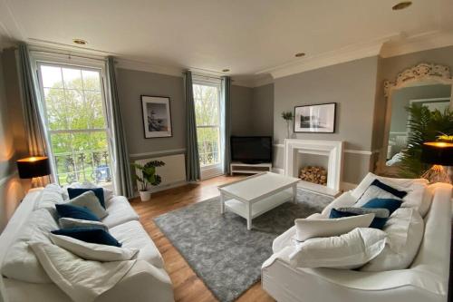 sala de estar con sofá blanco y almohadas azules en Waimea House Beach Front The best sea views en Scarborough