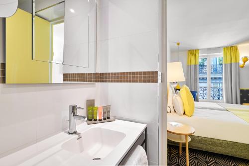 La salle de bains est pourvue d'un lavabo et d'un lit. dans l'établissement Hôtel Augustin - Astotel, à Paris
