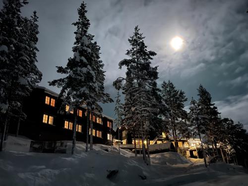 Un edificio nella neve con la luna nel cielo di Pollfoss Hotell a Skjåk