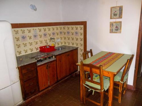 een keuken met een tafel, een tafel en een fornuis bij Apart Cuidad de Córdoba in Termas de Río Hondo