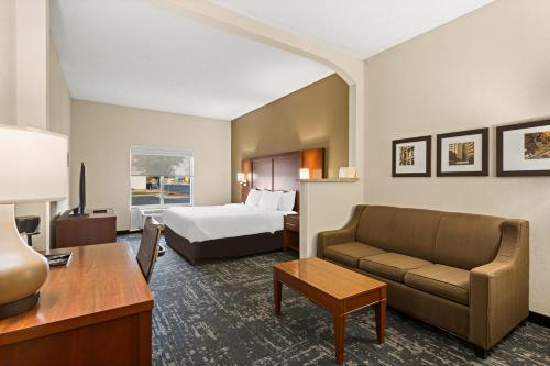 Habitación de hotel con cama y sofá en Comfort Suites Kansas City-Liberty, en Liberty