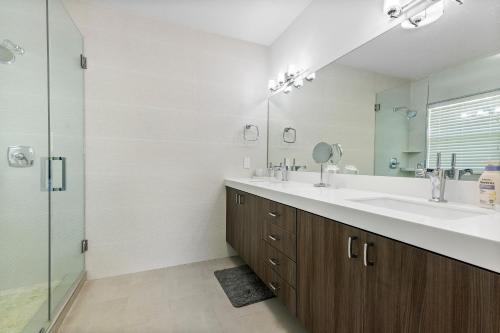 a bathroom with two sinks and a shower at Elegant 3BR w Pool Near Downtown WPB in West Palm Beach