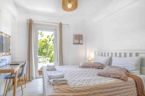 a bedroom with a bed with a desk and a window at Antonia in Plakias