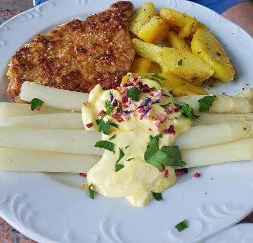 einen Teller mit Pommes frites und Fleisch in der Unterkunft Augustusgabe Barby in Barby