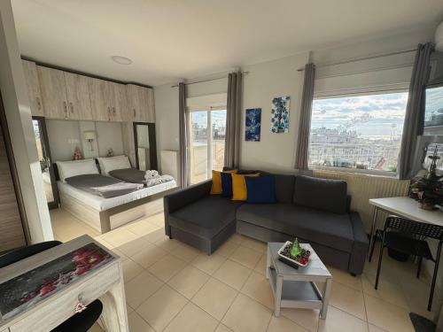 un soggiorno con divano e letto di Horizon /Downtown Penthouse w/ massive terrace a Salonicco