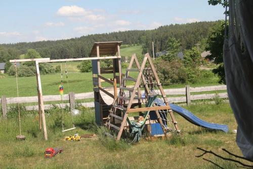 een speeltuin met een ladder en een glijbaan in een veld bij W Korcu Maku - dom wakacyjny in Rutka Tartak