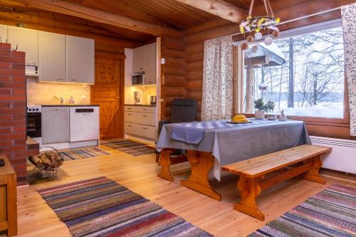 a kitchen and dining room with a table and a window at Suvituuli in Kuusamo