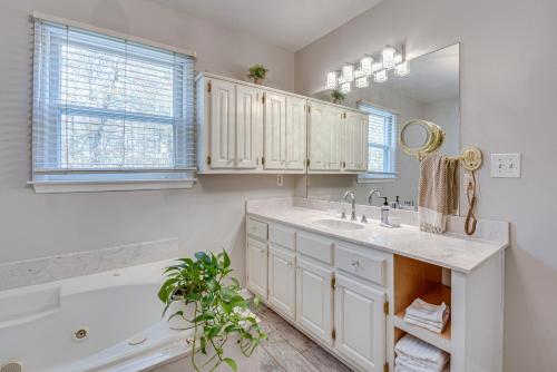 een witte badkamer met een wastafel, een bad en een spiegel bij Historic Covington Getaway with Fireplace and Yard! in Covington
