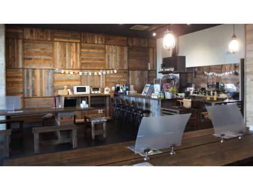 un restaurante con paredes de madera y una barra con mesas y sillas en GUEST HOUSE MASAGO - Vacation STAY 13806v, en Urakawa