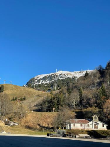 a house on a hill with a snow covered mountain at Studio Cabine Chamrousse in Chamrousse