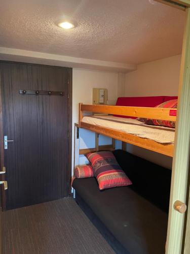 a room with two bunk beds and a door at Studio Cabine Chamrousse in Chamrousse