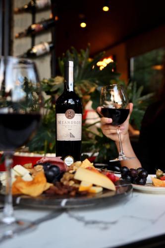 a person holding a glass of wine next to a plate of food at Comfort Suites in Alanya