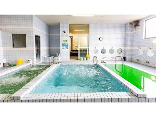 a pool in a bathroom with a green tub at GUEST HOUSE MASAGO - Vacation STAY 13810v in Urakawa