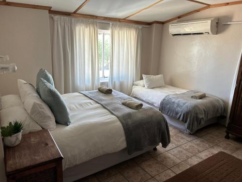 1 dormitorio con 2 camas y ventana en Namgate Guesthouse en Grünau