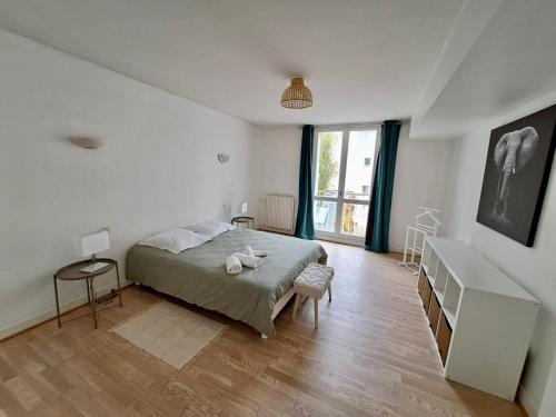 Un dormitorio con una cama y una ventana grande. en Very beautiful apartment right in the center, en Versalles