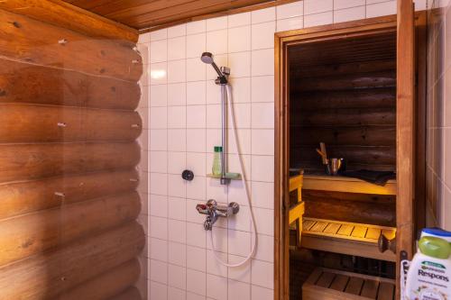 a shower in a bathroom with a wooden door at Iltarusko in Kuusamo