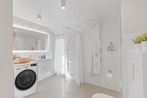 ein weißes Bad mit einer Waschmaschine in der Unterkunft FEEL HOME Apartments in Schönaich