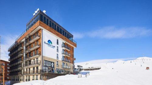a large building on top of a snow covered slope at Gudauri Loft Apartment N508 in Kʼumlistsʼikhe