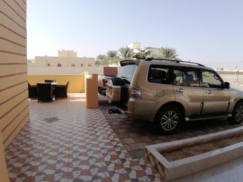 a suv parked on a patio with a table at Hotel Ain Safnan Room&Flats فندق عين صفنان غرف&شقق in Sanāw