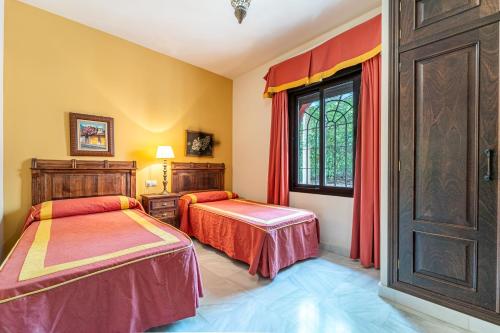 ein Schlafzimmer mit zwei Betten und einem Fenster in der Unterkunft Hacienda San Marcos in Baena
